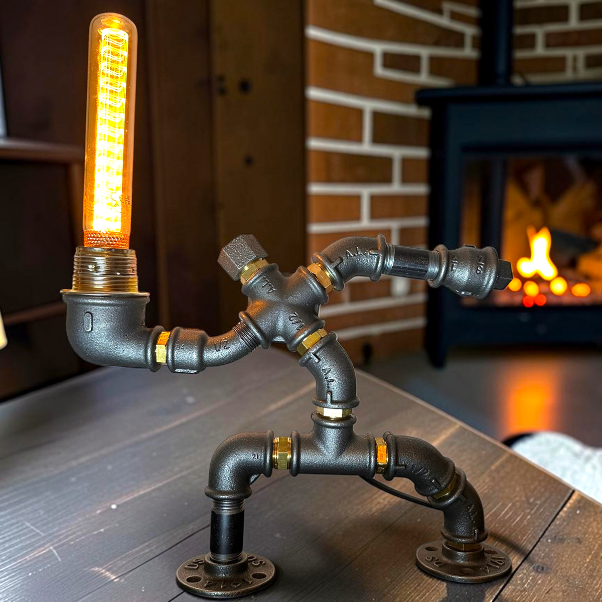 IronPunky Hampelmann Tischleuchte aus schwarzem Industrierohr mit leuchtender Edison-Glühbirne im Vintage-Stil