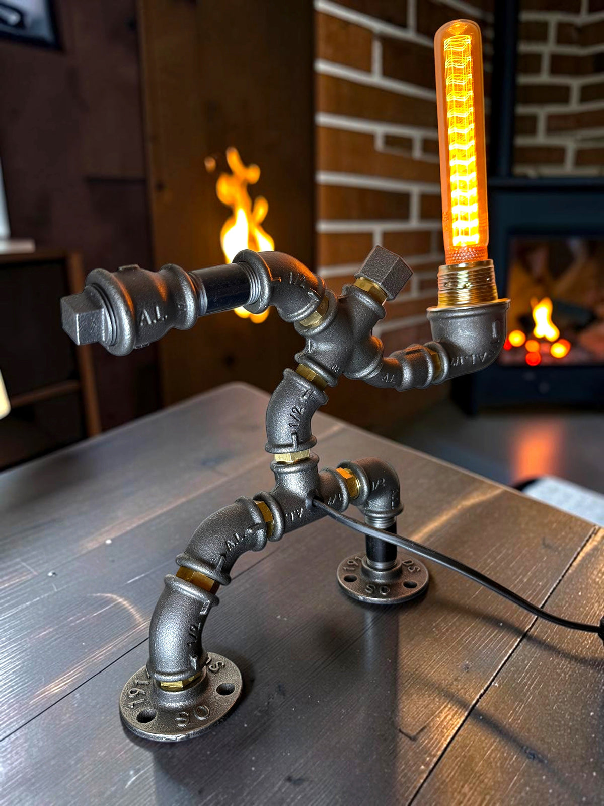 IronPunky Hampelmann Tischleuchte aus schwarzem Industrierohr mit leuchtender Edison-Glühbirne im Vintage-Stil